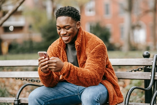 black man excited and smiling purchasing book and audio books online